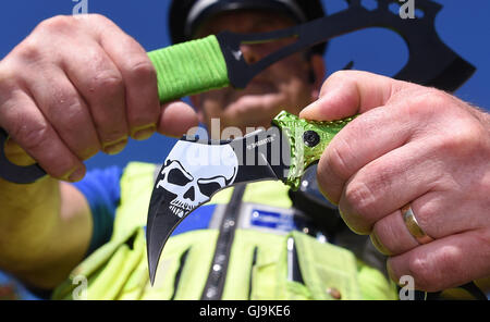 Sperrfrist bis Montag 15. AUGUST 0001 West Midlands PCSO Rob Capella hält zwei Beispiele für "Zombie-Messer" an einem sicheren Polizei-Standort in Birmingham als eine geänderte Gesetz bedeutet, dass ab nächsten Donnerstag, wer produziert, verkauft, vermietet, importiert oder verleiht ein "Zombie-Messer" ein Verbrechen und Gesichter sechs Monate hinter Bars und/oder einer Geldbuße begeht. Stockfoto