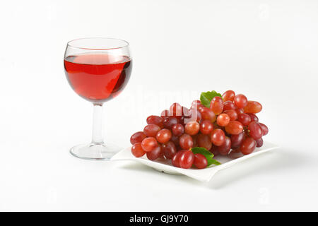 Platte Reifen roten Trauben und Rotwein auf weißem Hintergrund Stockfoto