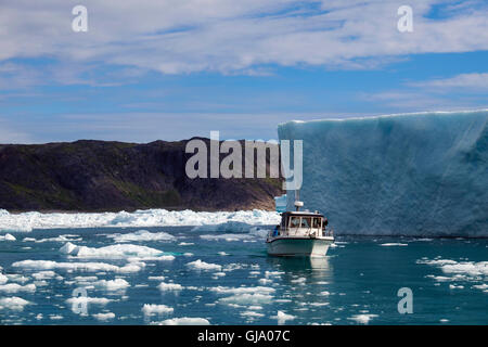 Kleines Ausflugsboot im Eissegeln im Tunulliarfik-Fjord in der Nähe von großen Eisberge aus Qooroq Eisfjord. Narsarsuaq Südgrönland Stockfoto