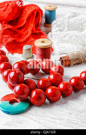 Leuchtend rote Korallen Perlen, Spitze und Perlen Gruppe von threads Stockfoto