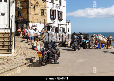 Motorradfahrer kommen außen The Bay Hotel. In Robin Hoods Bay, North Yorkshire, England. Auf Stockfoto