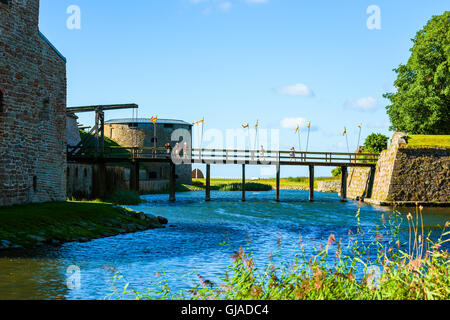 Kalmar, Schweden - 10. August 2016: Menschen zu Fuß über eine schmale Holzbrücke das Kalmar Schloss. Ein kleiner Kanal läuft unter der Stockfoto