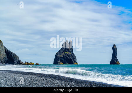 Blick auf berühmte Reynisdrangar Felsformationen am Strand in der Nähe der Ortschaft Vik in Island zurück Stockfoto