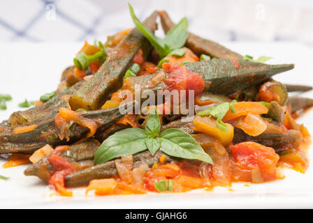 Okra-Schale geschmort mit Tomaten, Karotten und Zwiebeln Closeup (traditionelle griechische, rumänische, bulgarische und türkische Gericht) Stockfoto