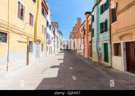 Straßen-Feature mit bunten Häusern in Chioggia, das Klein-Venedig, an einem Sommertag Stockfoto