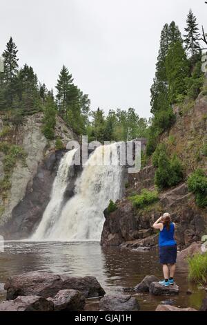 Eine Frau, die ein Bild von High Falls im Tettegouche State Park in Minnesota, USA. Stockfoto