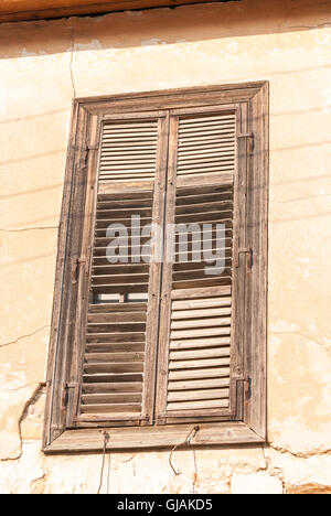 Alte rustikale schäbige grauen Fensterläden aus Holz auf einem Haus aus Stein Wand Closeup geschlossen. Kato Drys. Zypern. Stockfoto