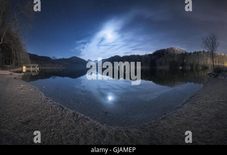 Übernachtung in Alpsee See Deutschlands. Schöne Landschaft mit See, Berge, Wald, Sterne, Vollmond Stockfoto