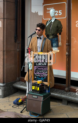 Ein Straßenmusikant auf der Princes Street, Edinburgh, das Geld für den Zug nach London. Stockfoto