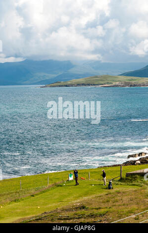 Zwei Golfer abschlagen auf Insel Harris Golf Course in den äußeren Hebriden mit Ton z. und North Harris im Hintergrund Stockfoto