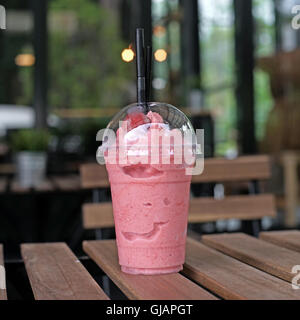 süße Erdbeer Smoothie Take away Cup auf Holztisch Stockfoto