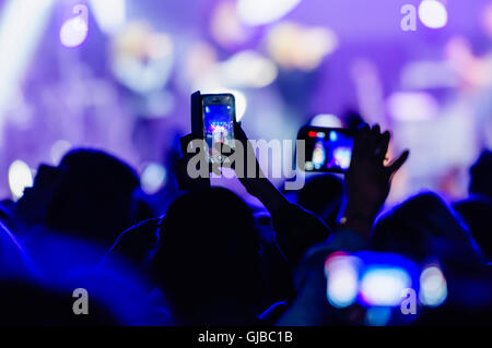 Mitglieder des Publikums Videos aufzeichnen eine Leistung bei einem Konzert mit ihren Smartphones. Stockfoto