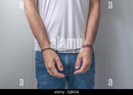 Mann mit gefesselten Händen festgenommen. Nicht erkennbare männliche Person in Jeans mit Handschellen statt in Polizeistation für Verdacht der Stockfoto