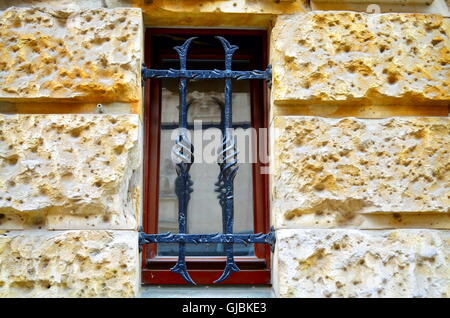 Fenster mit Metallstangen auf Straßenniveau Stockfoto