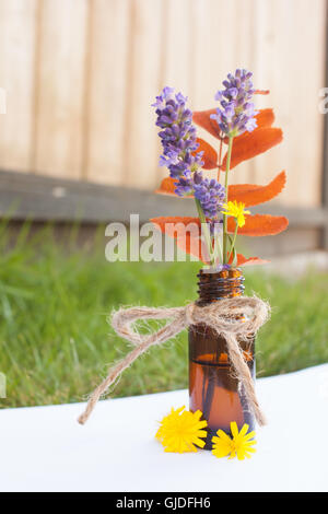 Ätherisches Öl Flasche mit Lavendel und Blumen Stockfoto