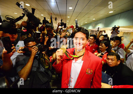 Singapur. 15. August 2016. Singapurs Goldmedaillengewinner posiert für ein Foto hält seine Goldmedaille in Singapurs Changi Airport, 15. August 2016 Joseph Schooling (C). Singapurs erste jemals Olympiasieger Joseph Schule kehrt im Triumph aus Brasilien Rio De Janeiro nach Jubel der Nation mit einer Goldmedaille im Herren 100m Schmetterling-Finale am Samstag. © Dahin Chih Wey/Xinhua/Alamy Live-Nachrichten Stockfoto