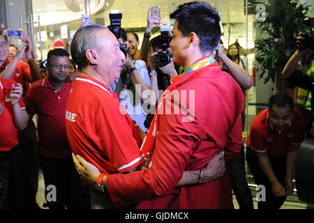 Singapur. 15. August 2016. Singapurs Goldmedaillengewinner Joseph Schooling (R) umarmt seinen Vater Colin Schulbildung am Singapurs Changi Airport, 15. August 2016. Singapurs erste jemals Olympiasieger Joseph Schule kehrt im Triumph aus Brasilien Rio De Janeiro nach Jubel der Nation mit einer Goldmedaille im Herren 100m Schmetterling-Finale am Samstag. © Dahin Chih Wey/Xinhua/Alamy Live-Nachrichten Stockfoto