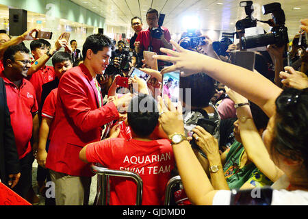 Singapur, Singapur Changi Airport. 15. August 2016. Singapurs Goldmedaillengewinner Joseph Schule (L, vorn) gibt Autogramme für seine Fans am Singapurs Changi Airport, 15. August 2016. Singapurs erste jemals Olympiasieger Joseph Schule kehrt im Triumph aus Brasilien Rio De Janeiro nach Jubel der Nation mit einer Goldmedaille im Herren 100m Schmetterling-Finale am Samstag. © Dahin Chih Wey/Xinhua/Alamy Live-Nachrichten Stockfoto