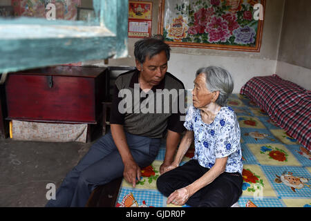 (160815)--TAIYUAN, 15. August 2016 (Xinhua)--Zhang Shuangbing, ein Lehrer des Dorfes, die sich freiwillig zu untersuchen, über die leiden und das Leben der Überlebenden Trostfrauen in China für 34 Jahre, Gespräche mit Liu Fenghai, eine Frau, die gezwungen wurde, als eine "Komfort-Frau" während dem zweiten Weltkrieg, in der Grafschaft Yu, Nord-China Shanxi Provinz, 3. August 2016 dienen. Montag markiert den 71. Jahrestag der bedingungslosen Kapitulation Japans am Ende des zweiten Weltkriegs. Etwa 400.000 Frauen in Asien wurden in Trostfrauen für die japanische Armee während des zweiten Weltkriegs, von denen fast die Hälfte Chinesen sind, nach einer res Stockfoto