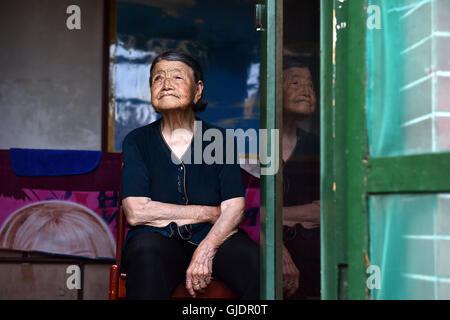 (160815)--TAIYUAN, 15. August 2016 (Xinhua)--Hao Yuelian, eine 88 Jahre alte Frau, die gezwungen wurde, als eine "Komfort-Frau" während des zweiten Weltkrieges zu dienen setzt sich ein Fenster in ihrem Haus in Yanggongling Dorf Wuxiang Grafschaft, Nord-China Shanxi Provinz, 2. August 2016. Montag markiert den 71. Jahrestag der bedingungslosen Kapitulation Japans am Ende des zweiten Weltkriegs. Etwa 400.000 Frauen in Asien wurden in Trostfrauen für die japanische Armee im zweiten Weltkrieg fast die Hälfte davon Chinesen sind, nach einem Forschungszentrum der Trostfrauen unter Geistes- und Kommunikation College Shangh Stockfoto