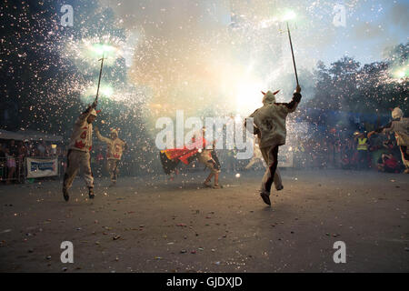 Gracia, Barcelona, Spanien. 15. August 2016. La Festa Gracia - Darsteller in Kostümen tanzen mit Fackeln auf Platz am Festival und Verrechnung Feuerwerk. Bildnachweis: Ceridwen Hughes/Alamy Live-Nachrichten Stockfoto