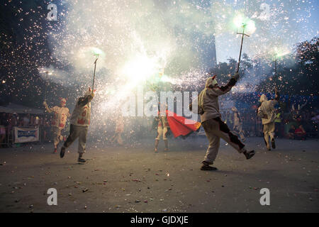 Gracia, Barcelona, Spanien. 15. August 2016. La Festa Gracia - Darsteller in Kostümen tanzen mit Fackeln auf Platz am Festival und Verrechnung Feuerwerk. Bildnachweis: Ceridwen Hughes/Alamy Live-Nachrichten Stockfoto