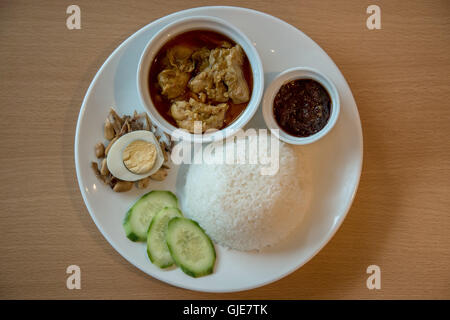 Nasi Lemak mit Chicken curry, Sardellen, gekochtem Ei, würziges Sambal und Reis Stockfoto