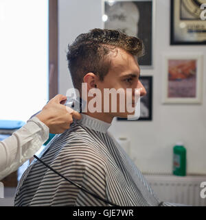 Teenager-Jungen in einem Friseur einen Haarschnitt bekommen Stockfoto