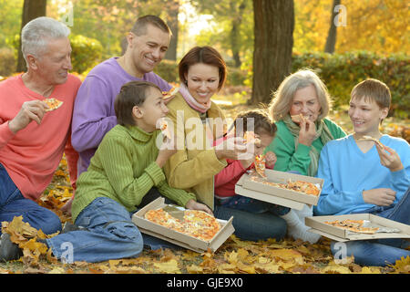 Familie Pizza essen im park Stockfoto