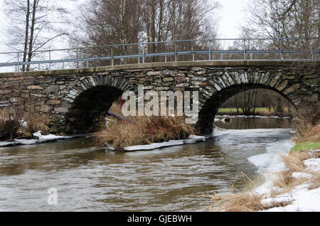 alten Stonebridge über dem kalten Wasser ein grauer Tag im zeitigen Frühjahr Stockfoto