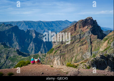 Gruppe von Touristen auf dem Felsen sitzt und mit Blick auf die Berglandschaft. Stockfoto