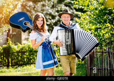 Paar in bayerischer Tracht mit Gitarre und Akkordeon Stockfoto