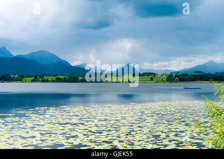 See in den deutschen Alpen mit einer Kette der Berge am Horizont. Spiegelung des Himmels im Wasser Stockfoto