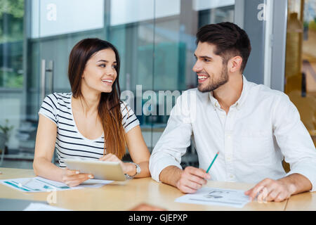 Glückliche junge Unternehmer und Unternehmerin Zusammenarbeit im Büro Stockfoto