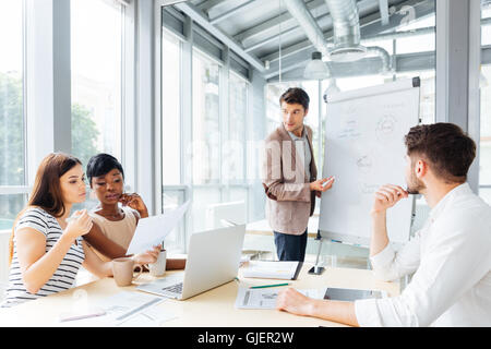 Hübscher junger Geschäftsmann, Präsentation mit Flipchart in office Stockfoto