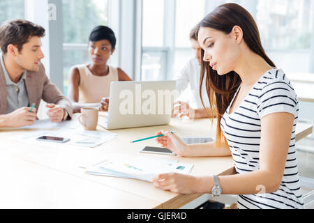 Junge Frau sitzen und arbeiten mit ihren Business-Team im Büro konzentriert Stockfoto