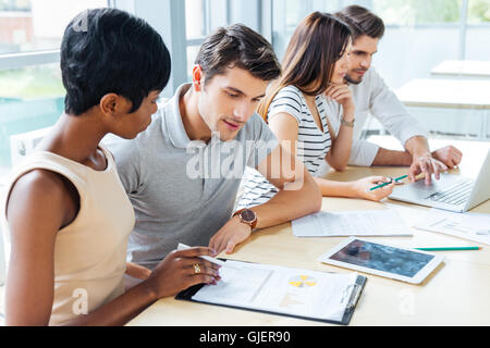 Multiethnische Gruppe von jungen Geschäftsleuten Erstellung Businessplan im Büro Stockfoto