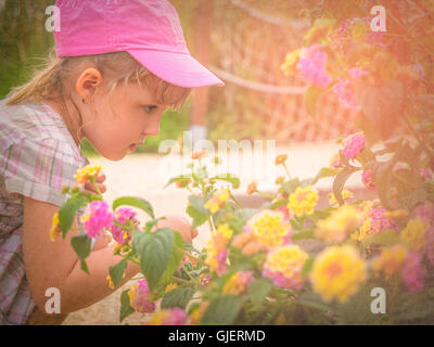 Kleines Mädchen im Frühjahr blühende Blumen riechen Stockfoto