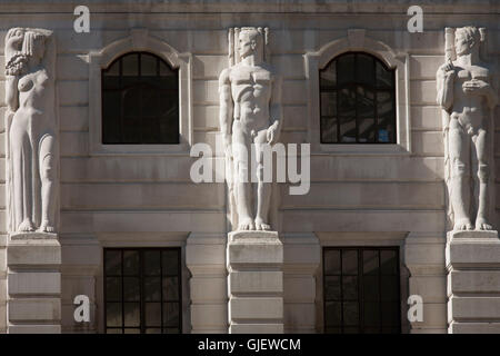 Mythischen griechischen männlichen Telamon Zahlen blicken einer weiblichen Karyatide-Skulptur an der Außenseite der Bank of England in der City of London. Stockfoto