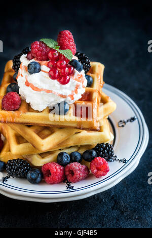 Traditionellen belgischen Waffeln im Teller mit Beeren und Eis am oberen, selektiven Fokus Stockfoto