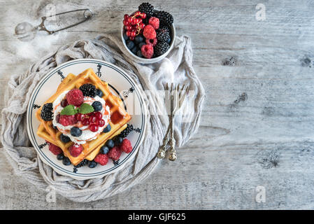 Belgien-Waffeln auf Holzbrett mit Beeren und Eis oben, Tiefenschärfe und leeren Raum Stockfoto