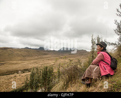 Auf der Ostseite des Berges Pichincha blickt eine einheimische Frau auf den Ausläufern der Anden. Stockfoto