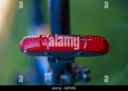 Roten hinteren Fahrrad Lampe mit grünen Hintergrund weichzeichnen Stockfoto