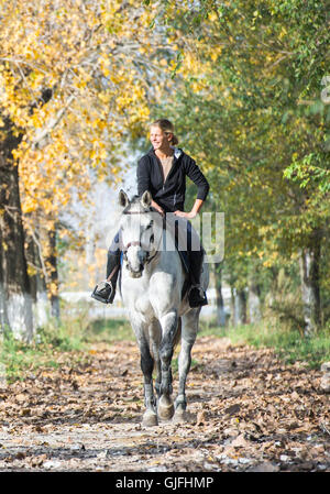 Mädchen auf einem Pferd im herbstlichen Wald Stockfoto