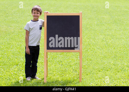 Kind Junge stand in der Nähe von der Tafel. Kopie im Freienraum für Text. Stockfoto