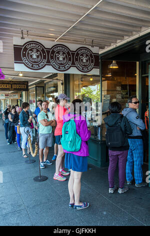 Leute in der Schlange kommt man in den Original Starbucks Kaffee Ort gegründet 1971 am Pike Place Market in Seattle, USA Stockfoto