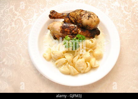 Gebackenes Huhn Bein Abendessen mit cremigen weißen Cheddar Makkaroni und Käse Stockfoto