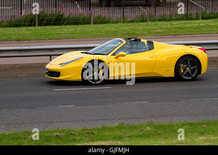 Ein gelber Ferrari 458 Italia Spider Cabrio Sportwagen Reisen entlang der Kingsway West Schnellstraße in Dundee, Großbritannien Stockfoto