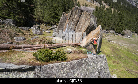 Eine Frau Bouldern auf Arete oder Klettern ohne Seile, im Sunderground Bereich der Zillertal, Österreich im Frühjahr. Stockfoto