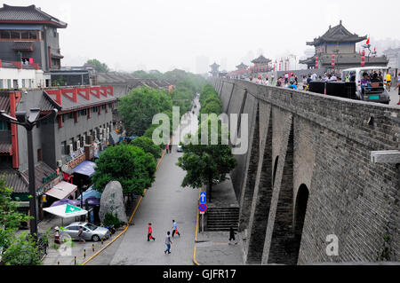 19. August 2015. Xian, China.  Chinesische Touristen zu Fuß auf der Stadtmauer von Xian, wie es sich über den Straßen in Shaanxi erhebt. Stockfoto